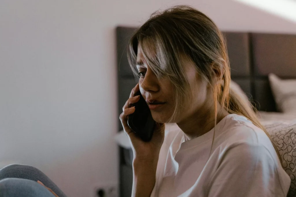 woman with mouth bruises on the phone