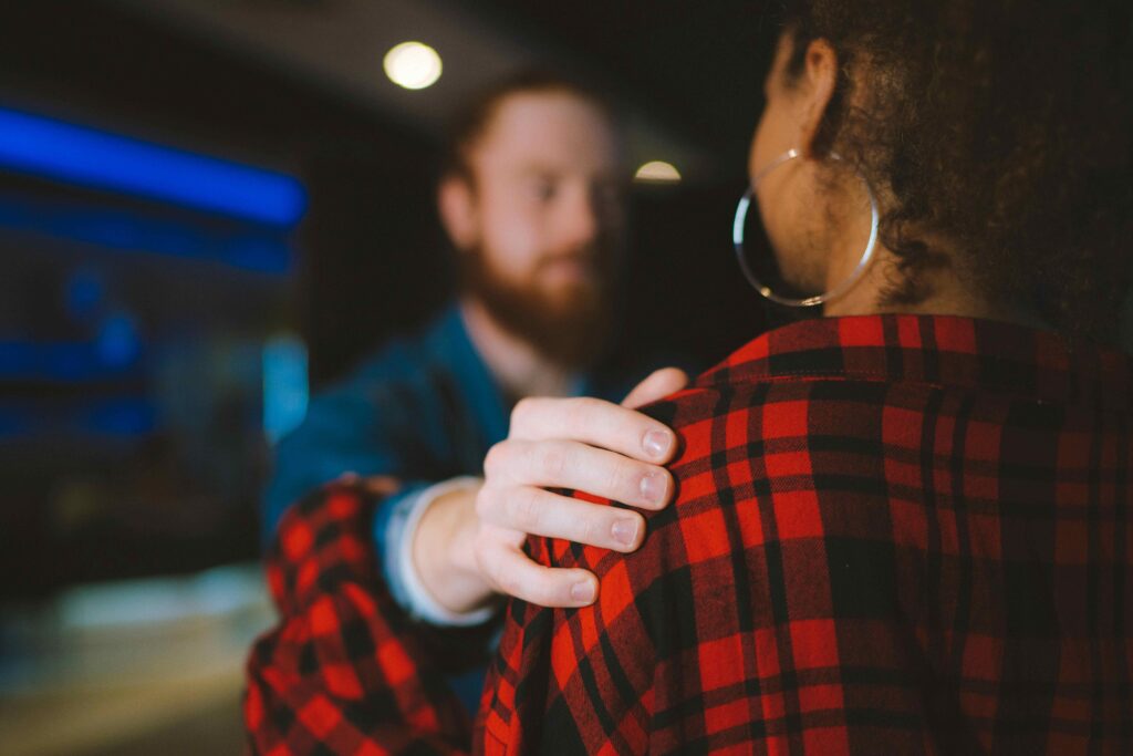 a man touching a woman's shoulder