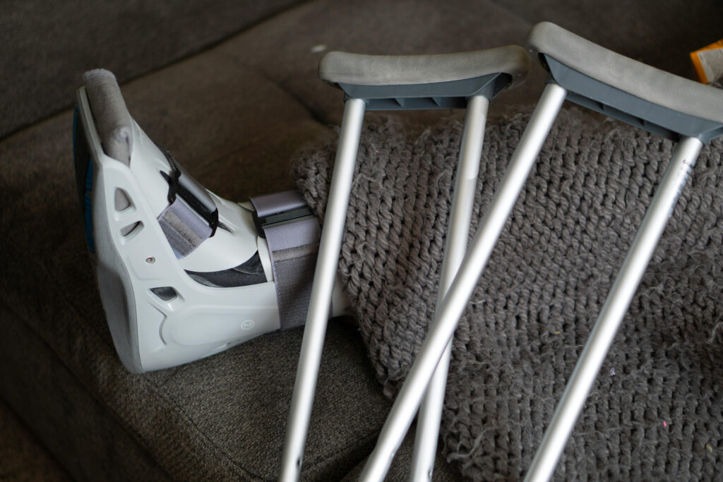 injured leg with orthopedic boot and crutches