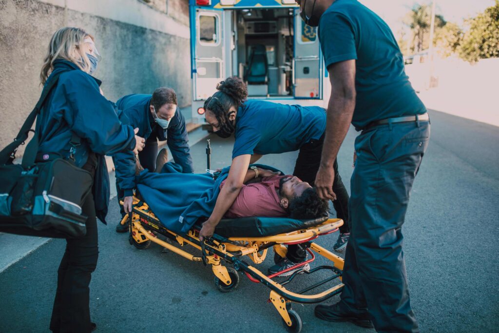 paramedic helping a victim to a stretcher