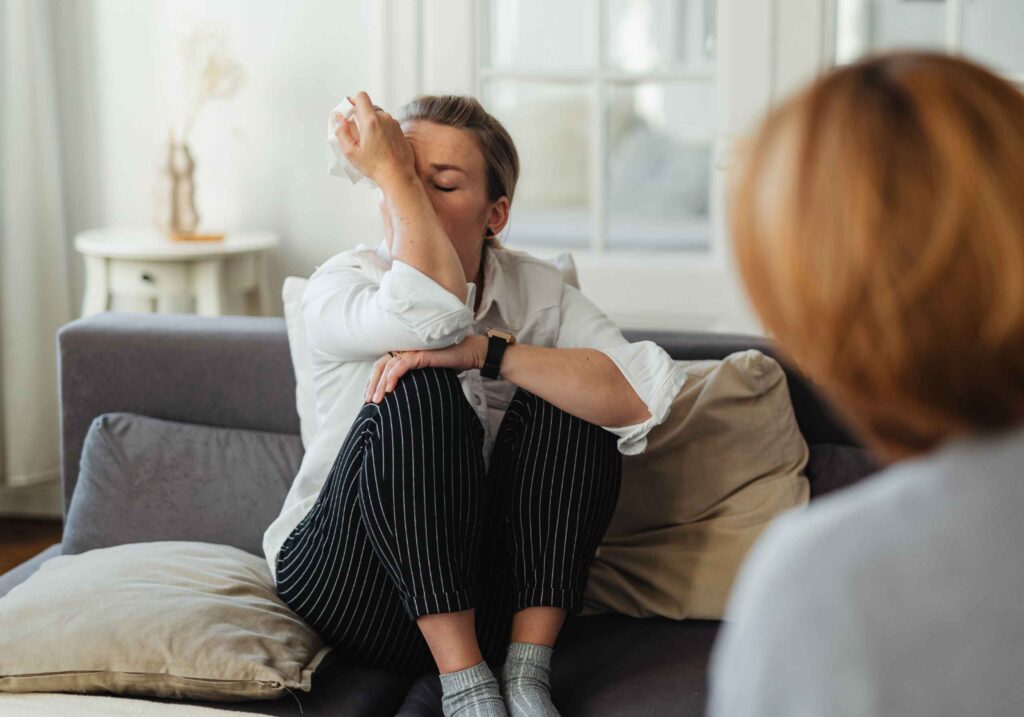 woman visibly upset during therapy session