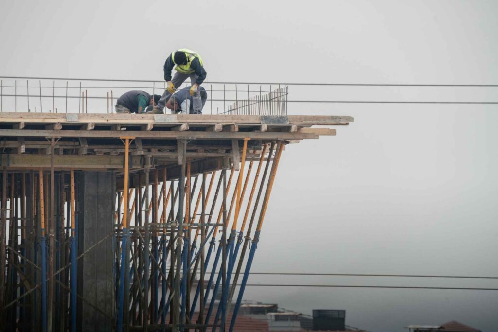Construction workers on an unfinished building edge
