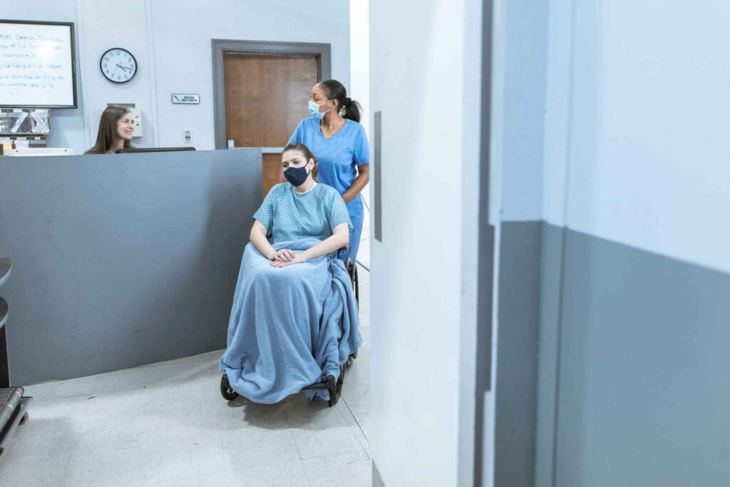Healthcare worker pushing a patient in a wheelchair